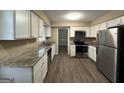 Modern kitchen with granite countertops, white cabinets, and stainless steel appliances at 2929 Stratford Mill Rd, Lithonia, GA 30038