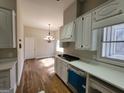 Bright kitchen with white cabinets, hardwood floors, and a chandelier at 275 Allie Dr, Mcdonough, GA 30252