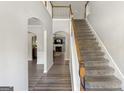Bright entryway with hardwood floors, staircase, and views into living room at 326 Cog Hill Dr, Fairburn, GA 30213