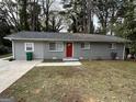 Ranch home with gray siding, red door, and green lawn at 1919 Glenmar Dr, Decatur, GA 30032