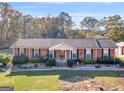 Brick ranch house with landscaped lawn and mature trees at 434 Lees Lake Rd, Fayetteville, GA 30214