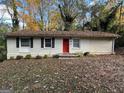 Updated brick ranch home with red door, nestled among autumn leaves at 2190 Westover Dr, East Point, GA 30344
