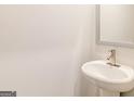 Small bathroom with pedestal sink, and a framed mirror at 145 Weldon St # 59, Mcdonough, GA 30253