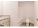 Main bathroom with tub, toilet, and granite countertop at 145 Weldon St # 59, Mcdonough, GA 30253