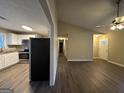 Open concept kitchen and living area with white cabinets at 245 Remington Trl, Ellenwood, GA 30294