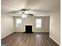 Living room with fireplace, hardwood floors, and multiple windows at 6235 Creekford Ln, Lithonia, GA 30058