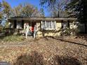 Brick ranch home with a red front door and mature trees at 2413 Ben Hill Rd, East Point, GA 30344