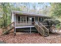 Front view of gray house with wooden stairs and deck at 215 Shadow Wood Dr, Douglasville, GA 30134