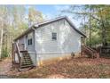Side view of a gray house with wooden stairs and deck at 215 Shadow Wood Dr, Douglasville, GA 30134