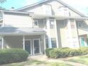 Two-story townhome featuring gray siding, teal doors, and well-maintained landscaping at 6390 Arbor Ln, Morrow, GA 30260