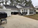 Spacious backyard with a patio, sunroom, grill, and white fence at 116 Winthrop Dr, Sharpsburg, GA 30277
