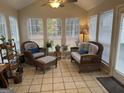 Bright sunroom with wicker furniture, plants, and tiled floor at 116 Winthrop Dr, Sharpsburg, GA 30277