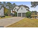 Two-story house with white exterior, landscaping, and a two-car garage at 12021 Scottish Ct, Fayetteville, GA 30215