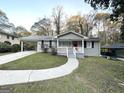 Updated ranch home features a red front door and a well-manicured lawn at 220 Oakcliff Nw Ct, Atlanta, GA 30331