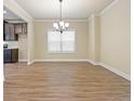 Empty dining room with hardwood floors, chandelier, and window with blinds at 2275 Lovejoy Rd # 72, Hampton, GA 30228