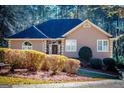 Tan house with a dark roof and landscaping, in a wooded setting at 417 Foggy Bottom Dr, Carrollton, GA 30116