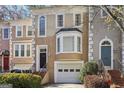 Inviting townhome showcasing a brick stairway, arched entryway, with a one-car garage and manicured bushes at 3863 Meeting St, Duluth, GA 30096