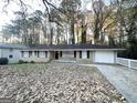 House exterior showcasing a ranch-style home with a driveway and mature trees at 2798 Engle Nw Rd, Atlanta, GA 30318