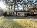 Brick ranch house with a red door, carport, and spacious yard at 3568 Glenview Cir, Atlanta, GA 30331