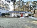 Gray sided ranch home with red front door and mature landscaping at 2312 Leslie Brook Dr, Decatur, GA 30035
