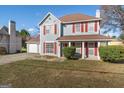 Two-story house with attached garage, red accents, and a yard at 453 Camp Hill Ln, Jonesboro, GA 30238