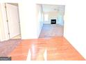 View of living room with hardwood and carpeted floors, fireplace and access to other rooms at 6195 Winston Trce, Mcdonough, GA 30252