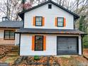 Exterior view of a renovated house featuring orange shutters and a gray garage door at 5211 Mountain Village Ct, Stone Mountain, GA 30083