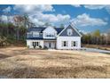 Two-story farmhouse with gray and white siding, landscaping, and a large yard at 1833 Tommy Lee Cook Rd, Palmetto, GA 30268