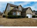 Two-story house with stone and siding accents, two-car garage, and landscaping at 6383 Edgewater Cv, Fairburn, GA 30213