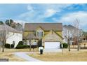 Two-story house with stone and siding, two-car garage, and front yard at 6383 Edgewater Cv, Fairburn, GA 30213