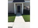 Welcoming front entry with white columns and black door at 160 Orchard Dr, Covington, GA 30014