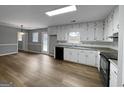 Bright kitchen with white cabinets, black appliances, and ample counter space at 165 Riverbend Dr, Covington, GA 30014