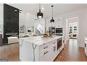 Modern kitchen with quartz island, stainless appliances, and open concept design to living area at 3920 Clifton Hill Ct, Cumming, GA 30040