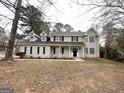 Two-story home with covered front porch and autumn leaves on the lawn at 1091 Cherry Laurel Dr, Lithonia, GA 30058