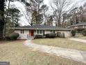 Front exterior view of a one-story house with a red door, curved walkway, and green lawn at 2003 Rosewood Rd, Decatur, GA 30032