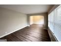 Empty living room with neutral walls, wood-look flooring, and an arched entryway at 2003 Rosewood Rd, Decatur, GA 30032