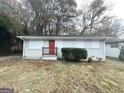Single-story home with a small front porch, red door, and some boarded-up windows at 3429 Adkins Nw Rd, Atlanta, GA 30331