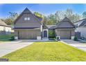 Modern farmhouse exterior with a three-car garage and landscaped front yard at 714 Magnolia Walk, Peachtree City, GA 30269