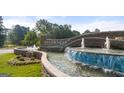 Community entrance featuring stone signage, lush landscaping, and a water feature at Sugarloaf at 1019 Cades Walk, Lawrenceville, GA 30045