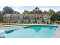 Community pool and townhomes featuring garages and fenced yards with mature trees at 1019 Cades Walk, Lawrenceville, GA 30045