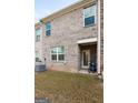 Back exterior of the townhome with a small patio and grassy area at 1304 Speckle Park Way, Stockbridge, GA 30281