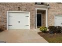 Close-up of the townhome's front exterior showcasing the brick facade and garage at 1304 Speckle Park Way, Stockbridge, GA 30281