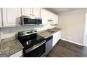 Modern kitchen featuring white shaker cabinets, granite counters, and stainless steel appliances at 261 Howell Sw Ter, Atlanta, GA 30331