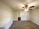 Spacious living room with neutral walls, plush carpet, and a ceiling fan at 261 Howell Sw Ter, Atlanta, GA 30331