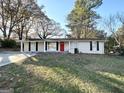 Charming exterior with a red door and lush landscaping at 6069 Wisteria Ln, Lithia Springs, GA 30122