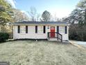 Inviting single-story home with a red door and a well-maintained lawn at 2843 Marco Nw Dr, Atlanta, GA 30318