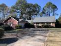 Two-story home with attached garage, driveway, front yard, and mature trees at 1603 Golf Link Dr, Stone Mountain, GA 30088