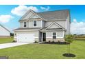 Inviting two-story home with a gray exterior, white trim, and a landscaped front yard at 928 Hesston Dr, Locust Grove, GA 30248