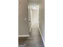 Bright hallway with light gray laminate flooring and neutral walls at 95 Grove Creek Dr, Locust Grove, GA 30248