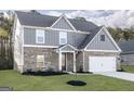 Two-story house with gray siding, brick accents, and a white garage door at 3402 Arabian Farm Ln, Dacula, GA 30019